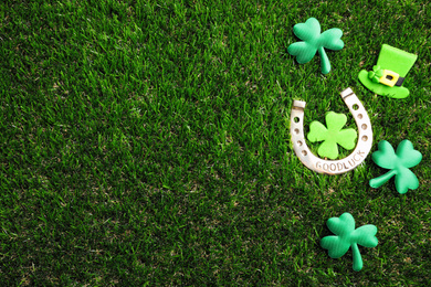 Photo of Flat lay composition with horseshoe on grass, space for text. St. Patrick's Day celebration