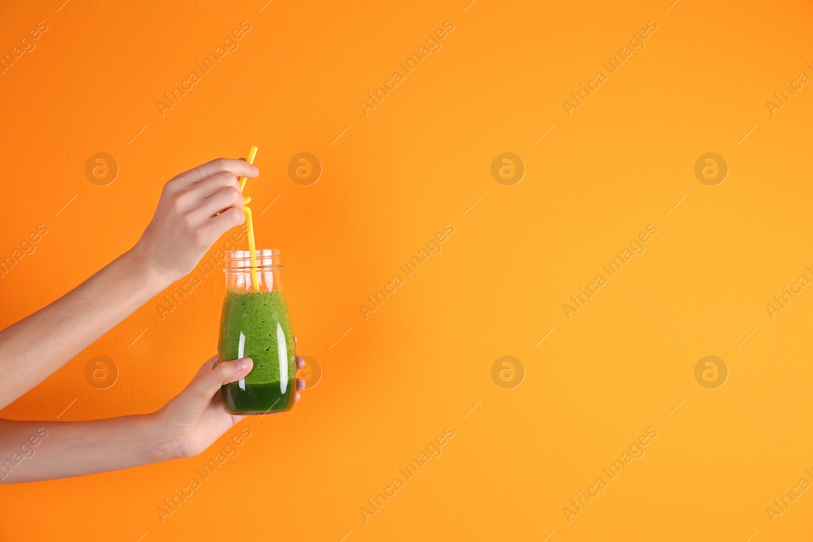 Photo of Young woman holding bottle of healthy smoothie on color background