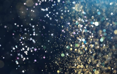 Image of Many beautiful shimmering stars and blurred lights on dark blue background. Bokeh effect