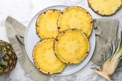 Slices of tasty ripe pineapple on white marble table, flat lay