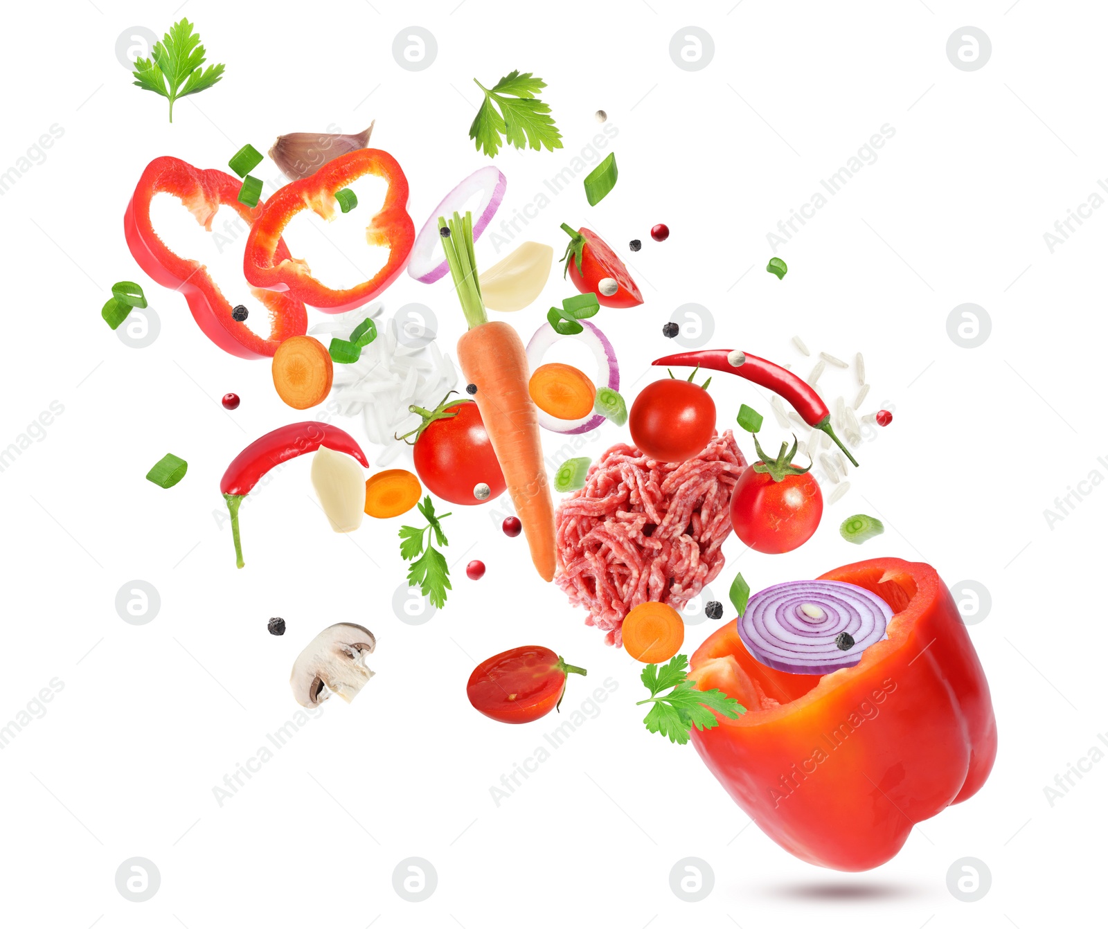 Image of Stuffed pepper recipe. Fresh ingredients falling into bell pepper on white background