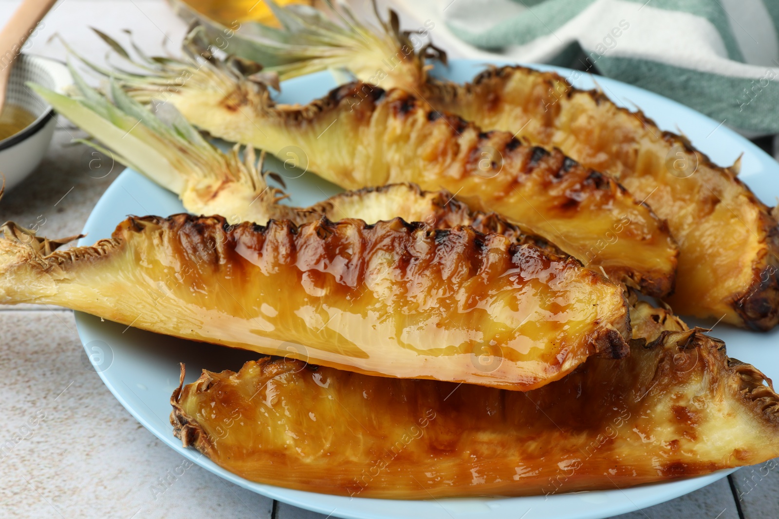Photo of Tasty grilled pineapples on light gray table, closeup