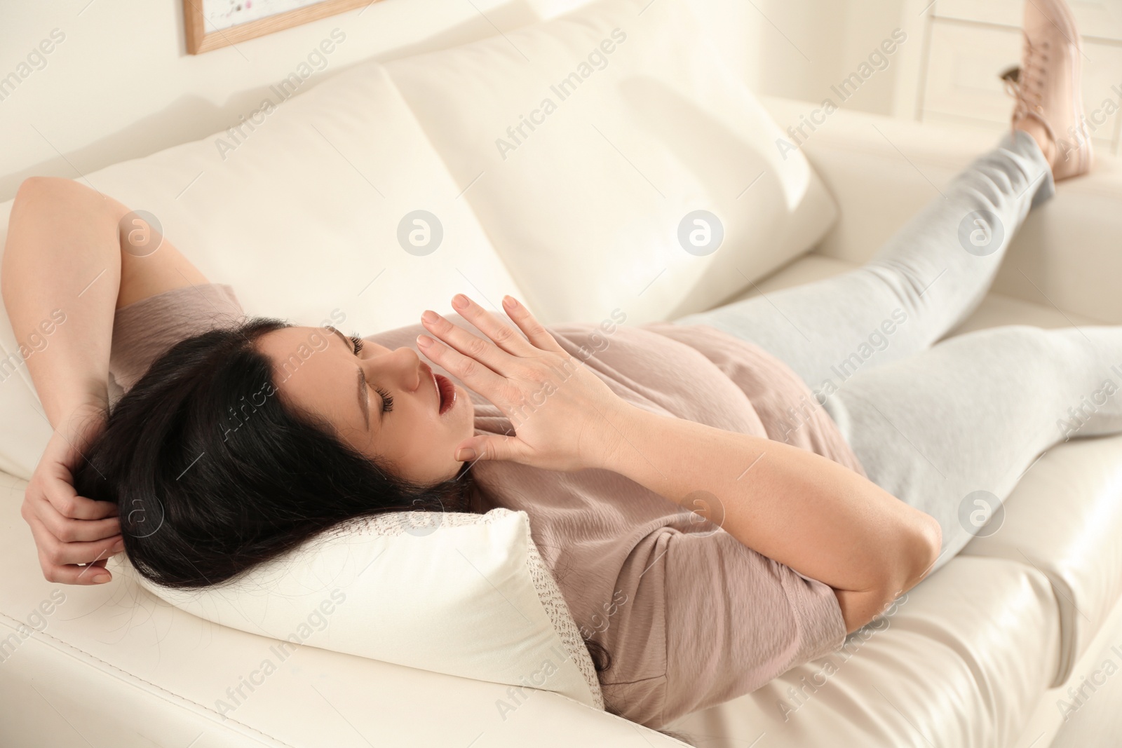 Photo of Lazy overweight woman resting on sofa at home