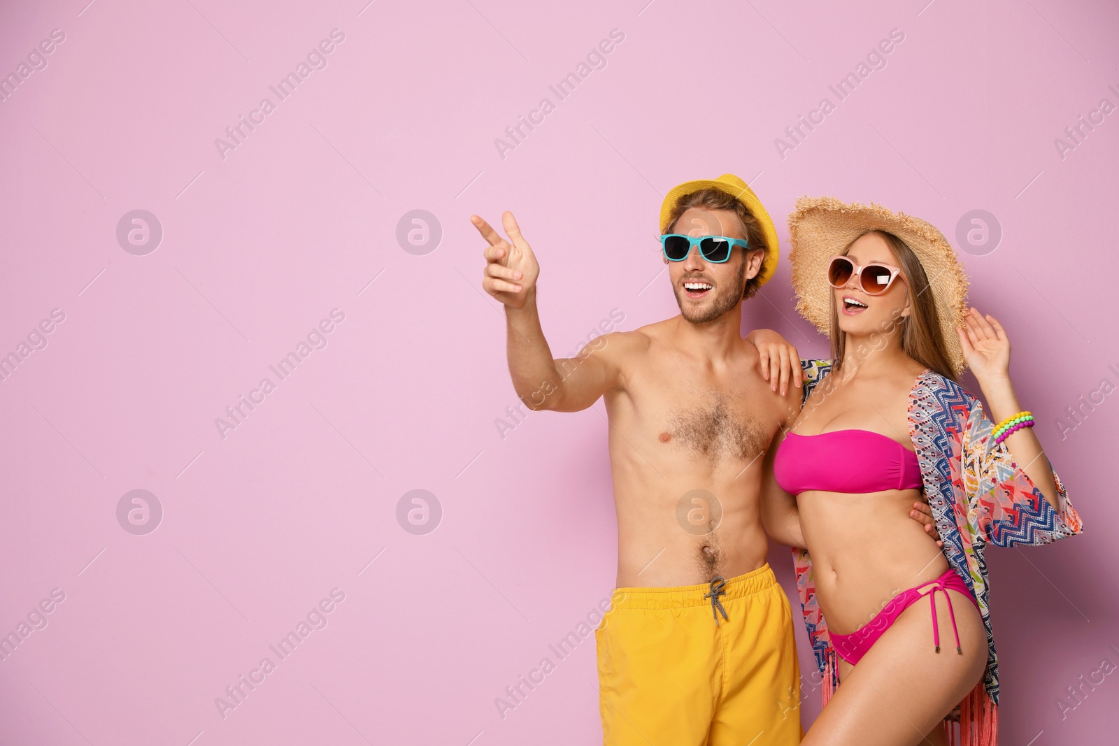 Photo of Happy young couple in beachwear on color background. Space for text