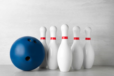 Blue bowling ball and pins on light grey marble table