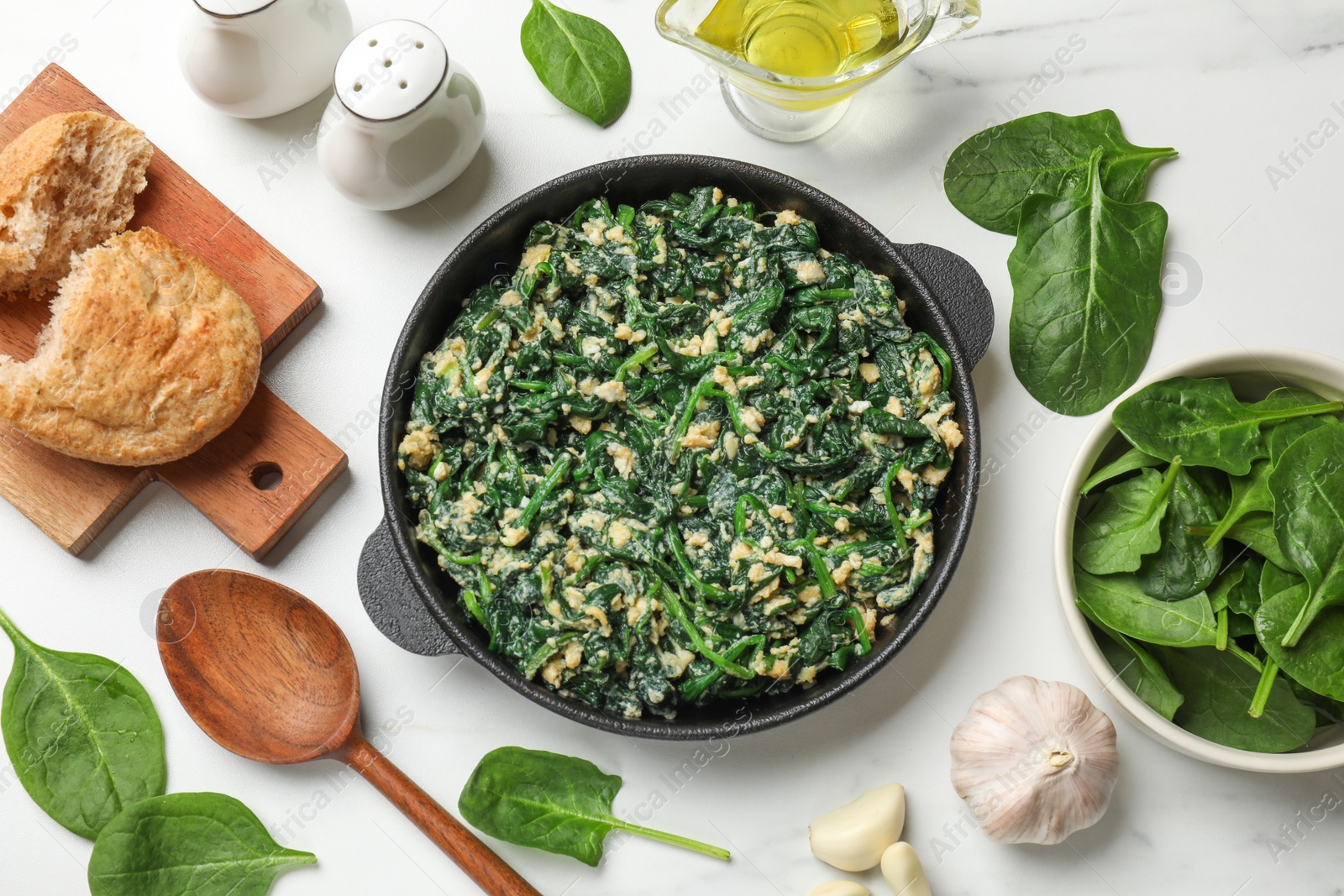 Photo of Tasty spinach dip with eggs in dish served on white table, flat lay