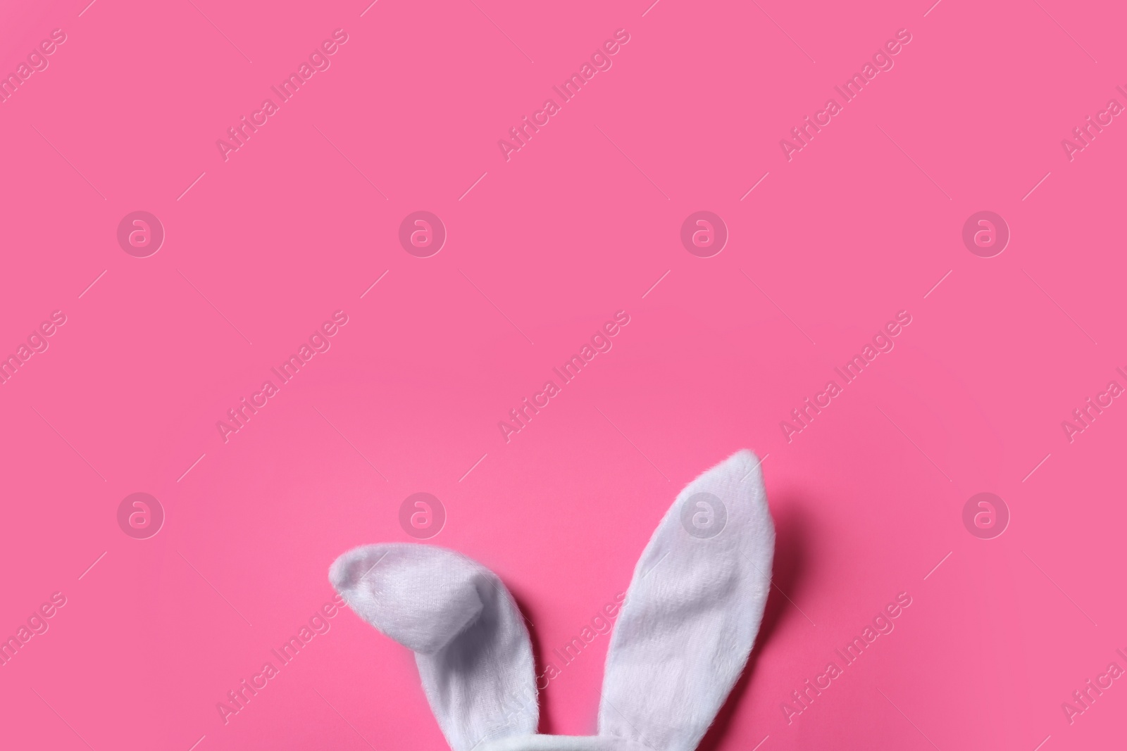 Photo of Funny Easter bunny ears on color background, top view with space for text