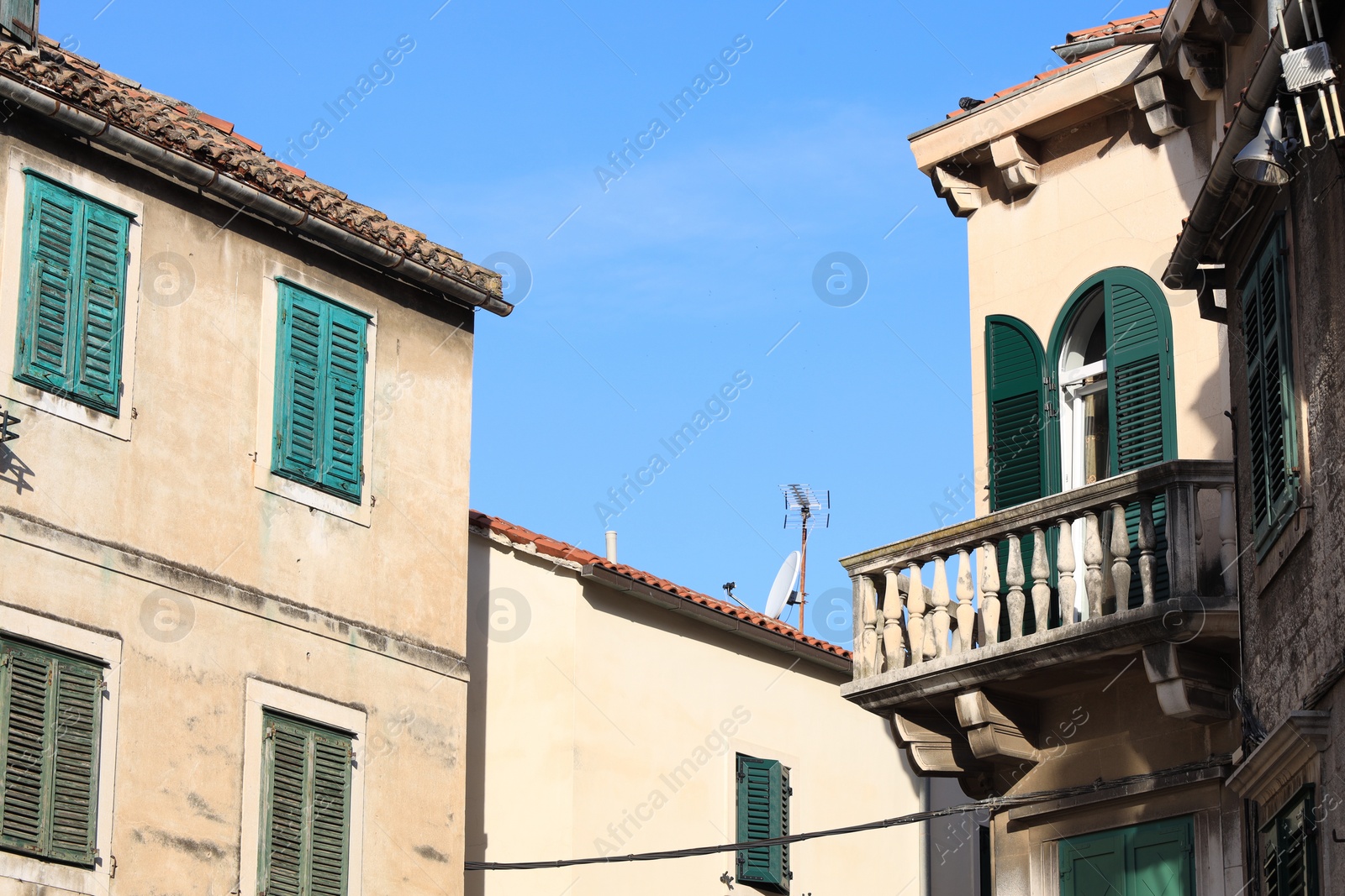 Photo of Exterior of old residential buildings against light blue sky
