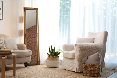 Photo of Elegant mirror near sofa in stylish living room interior