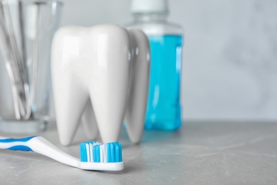 Photo of Brush and tooth shaped holder on table, space for text. Professional dentist