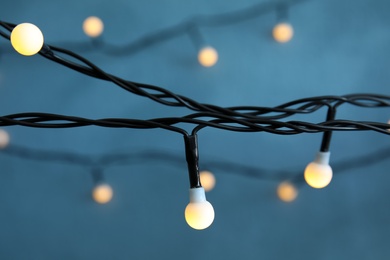 Photo of Beautiful Christmas lights on color background, closeup