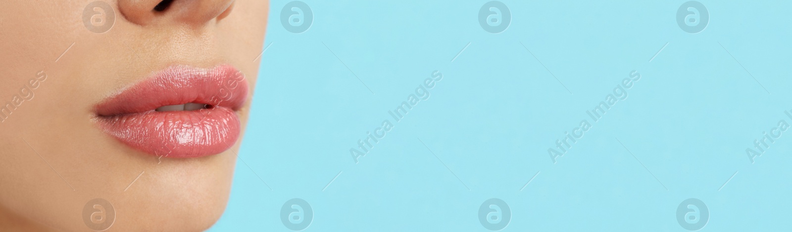 Image of Woman with beautiful lips on light blue background, closeup view with space for text. Banner design