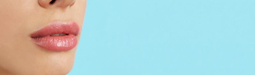 Image of Woman with beautiful lips on light blue background, closeup view with space for text. Banner design