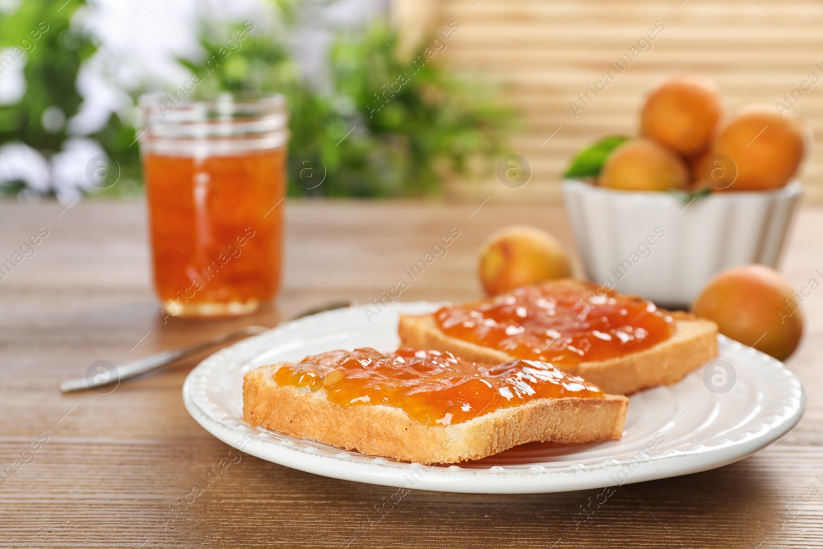 Photo of Bread with tasty apricot jam on plate