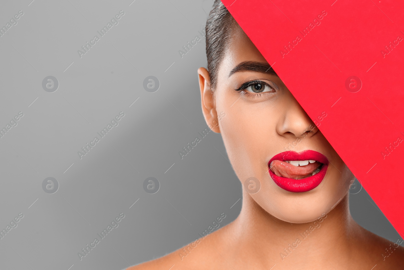 Photo of Young woman wearing beautiful lipstick on color background. Space for text