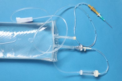 Photo of IV infusion set on light blue background, top view