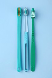 Many different toothbrushes on light blue background, flat lay