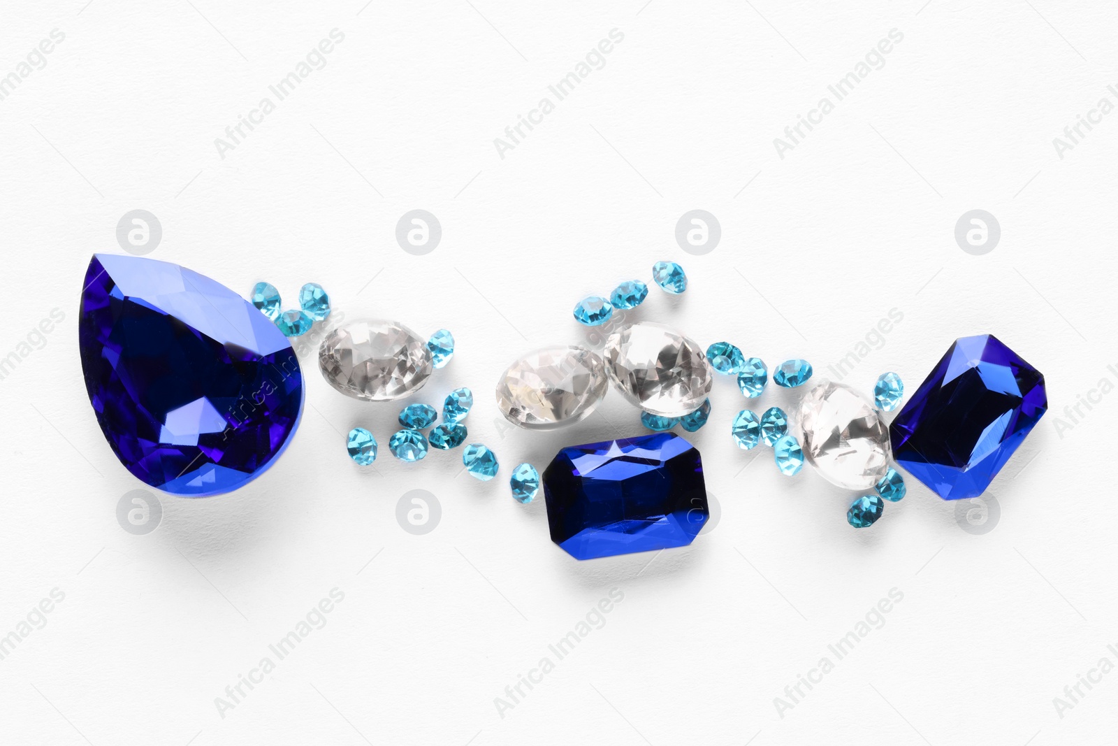 Photo of Different beautiful gemstones for jewelry on white background, top view