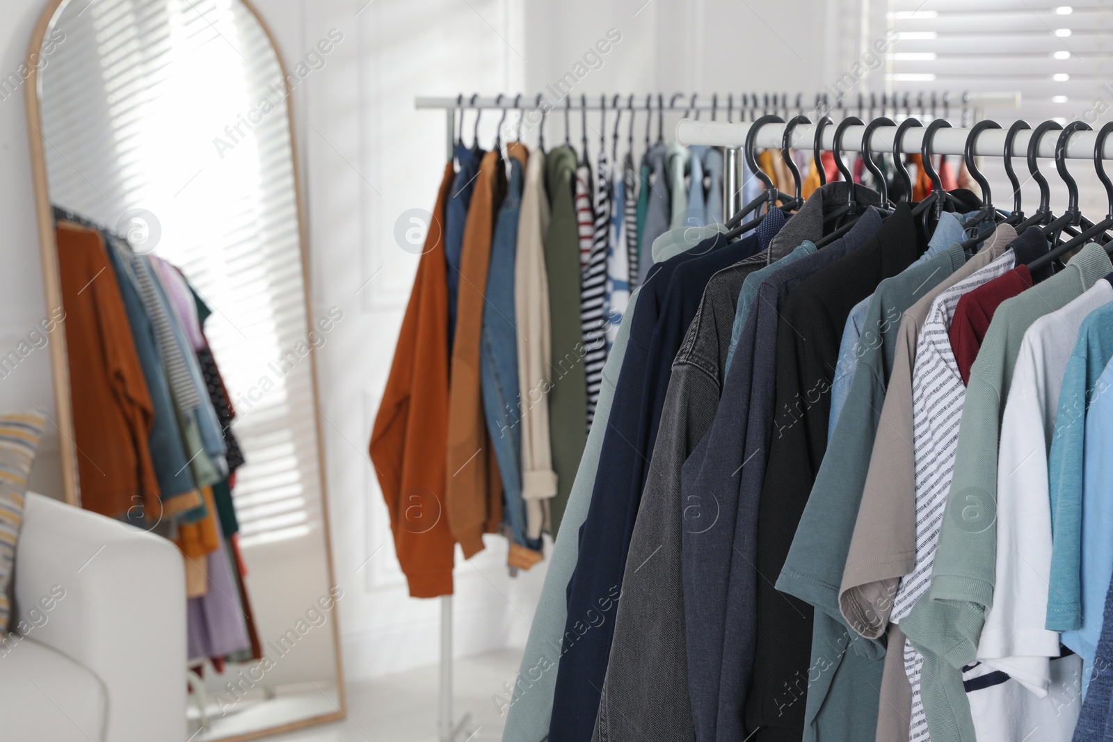 Photo of Racks with stylish clothes indoors. Fast fashion