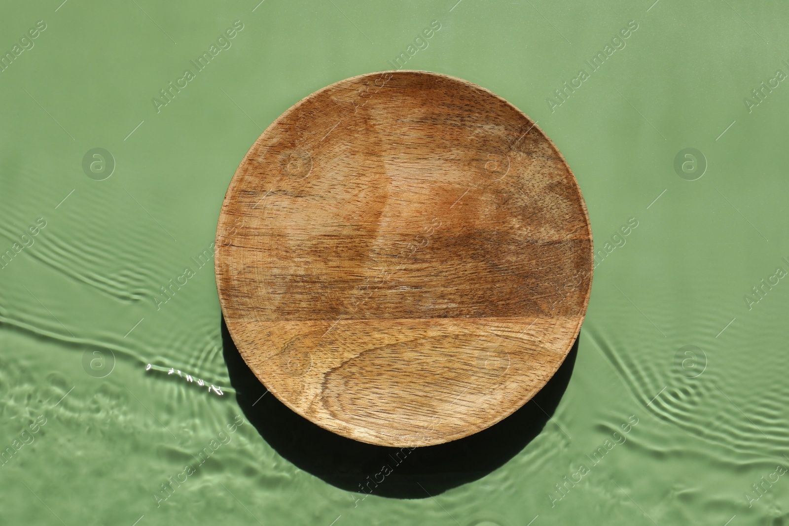 Photo of Presentation for product. Wooden podium in water on green background, top view