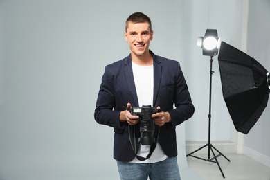 Professional photographer with modern camera in studio