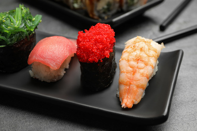 Photo of Set of delicious sushi on grey table