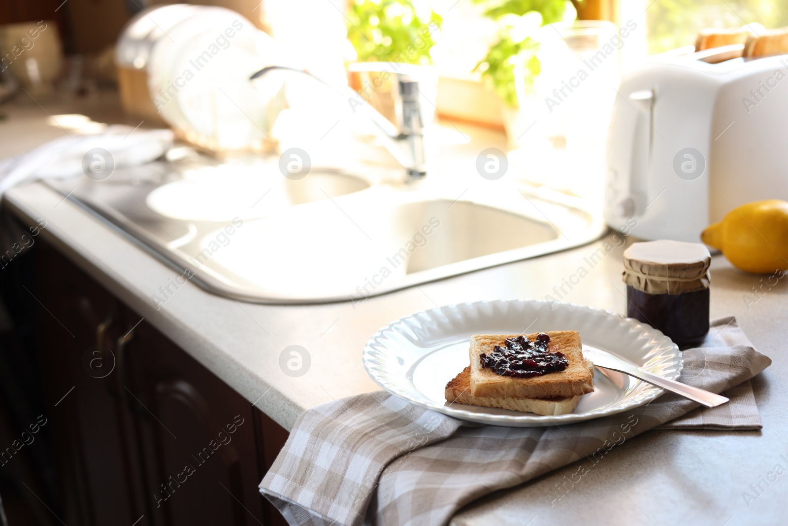 Photo of Tasty toasts with jam on countertop in kitchen, space for text