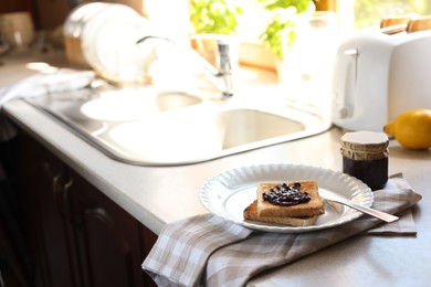 Photo of Tasty toasts with jam on countertop in kitchen, space for text