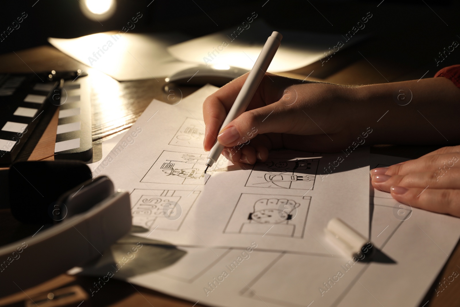 Photo of Woman drawing cartoon sketches at workplace, closeup. Pre-production process