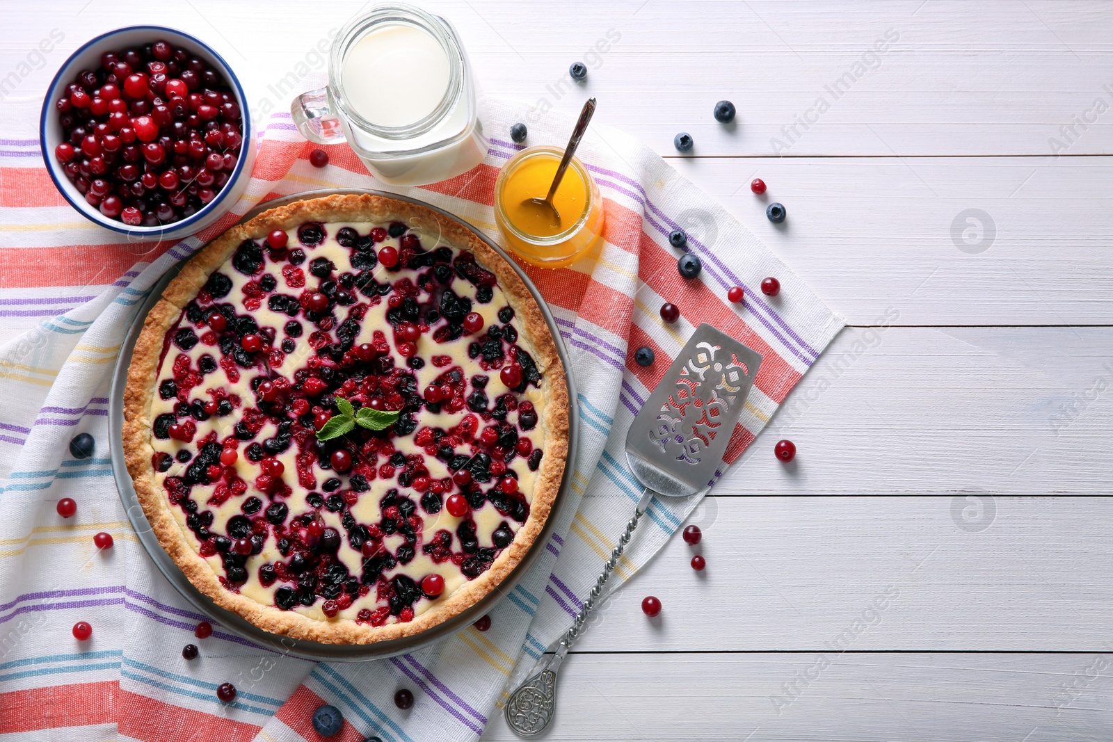 Photo of Delicious currant pie and fresh berries on white wooden table, flat lay. Space for text