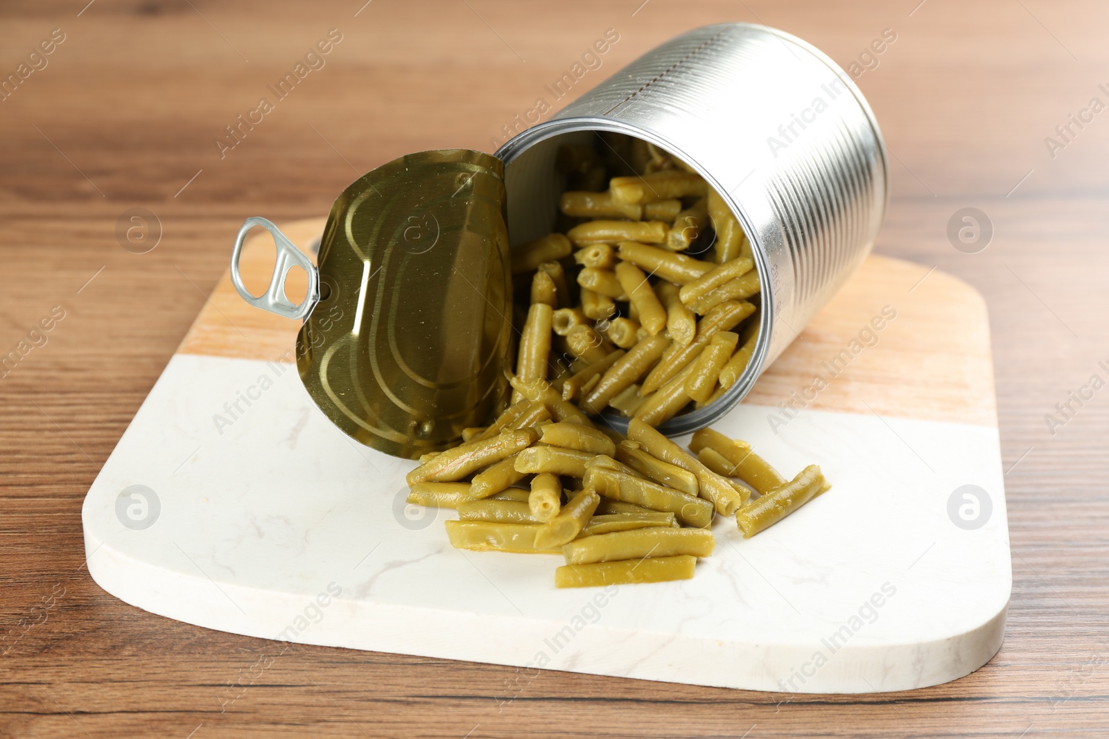 Photo of Canned green beans on wooden table, closeup