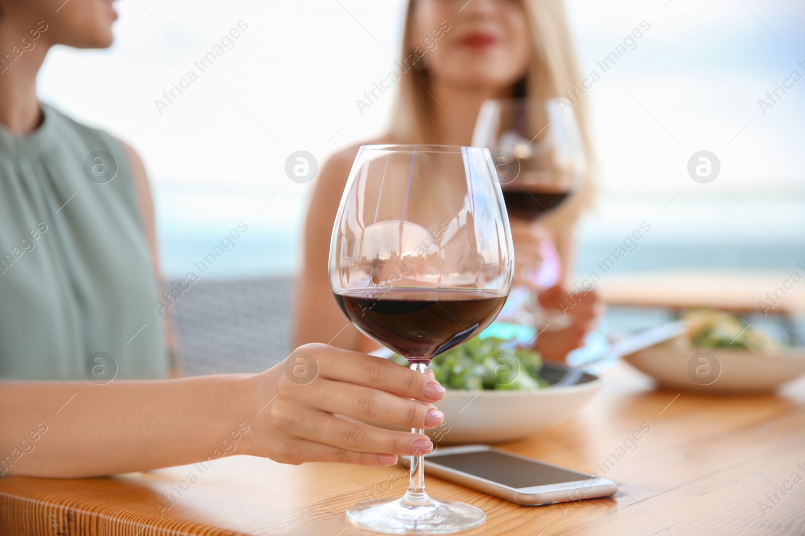 Photo of Young women with glasses of wine at table