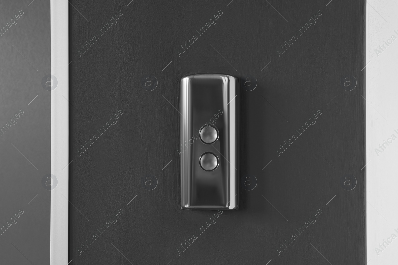 Photo of Elevator call buttons on grey wall, closeup