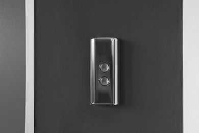 Photo of Elevator call buttons on grey wall, closeup