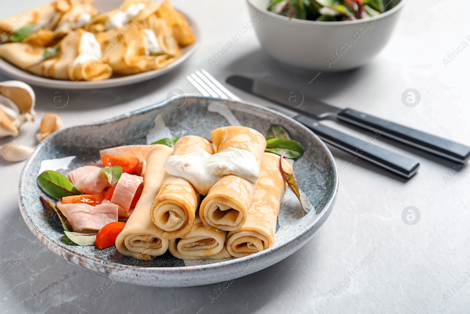 Photo of Thin pancakes with garnish on plate