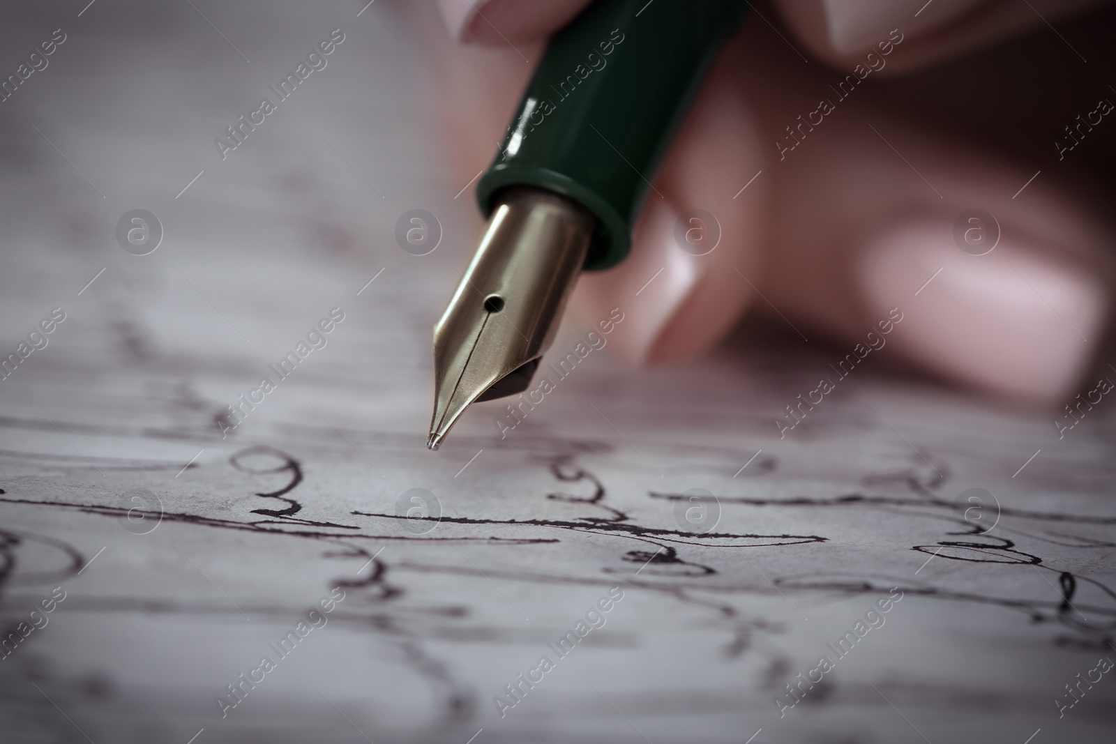 Image of Woman writing letter with fountain pen, closeup
