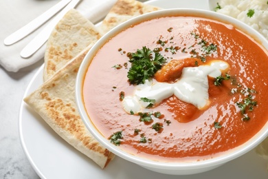 Photo of Delicious butter chicken in bowl served on table. Traditional Murgh Makhani dish