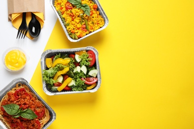 Photo of Lunchboxes on color table, flat lay. Healthy food delivery