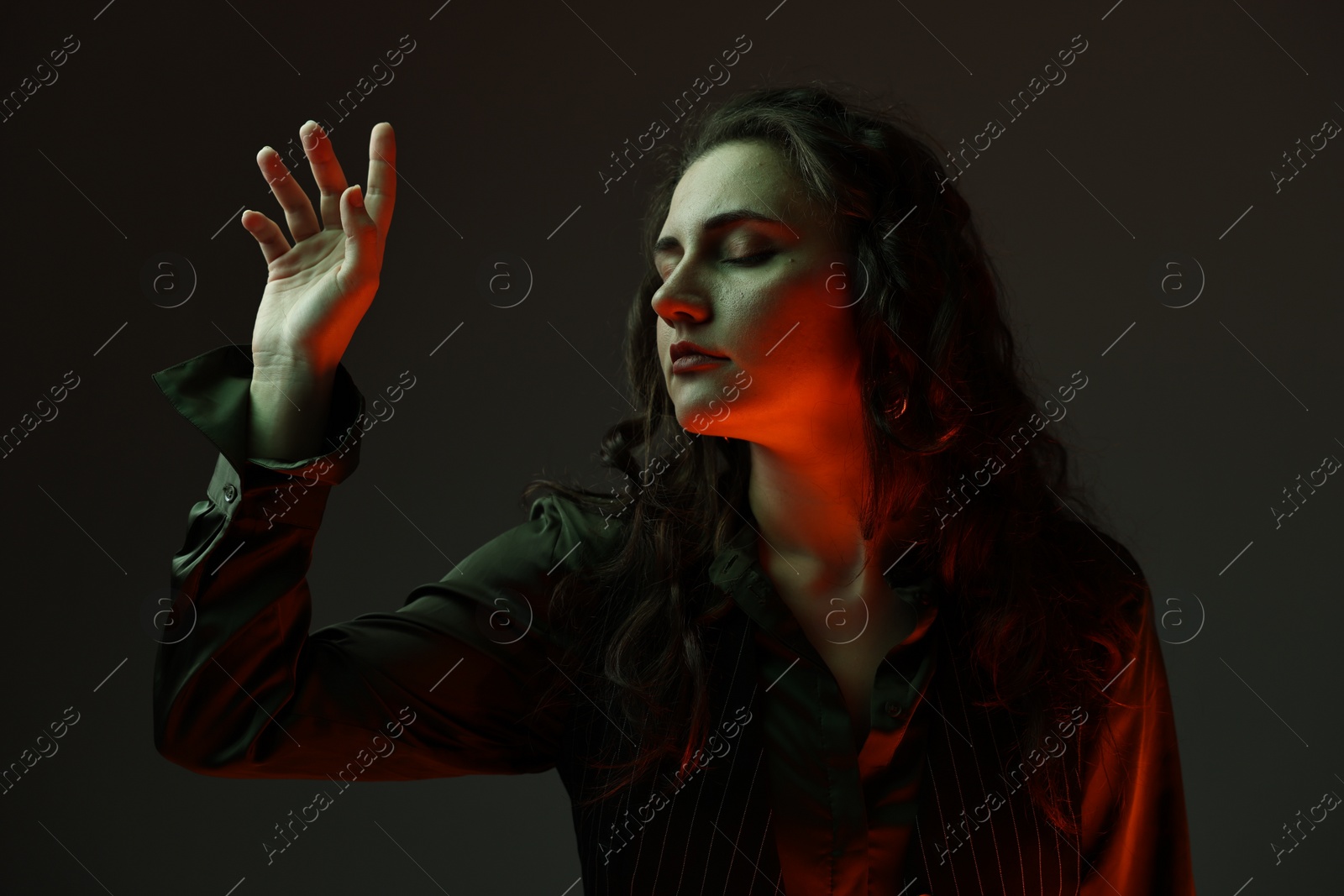 Photo of Portrait of beautiful young woman on dark background with neon lights