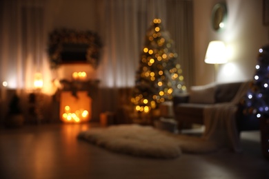 Blurred view of festive interior with Christmas tree and decorative fireplace