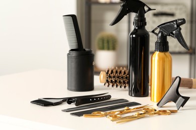 Photo of Hairdresser tools. Different scissors and combs on white table in salon