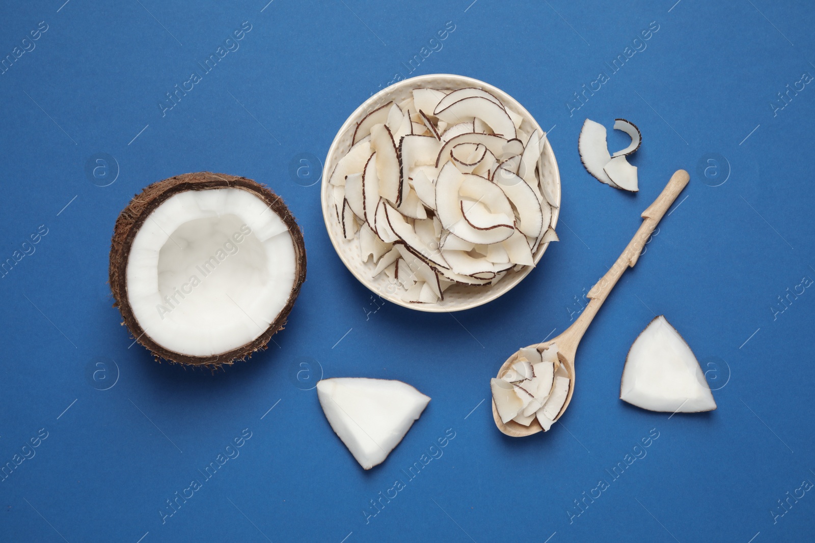 Photo of Flat lay composition with tasty coconut chips on blue background