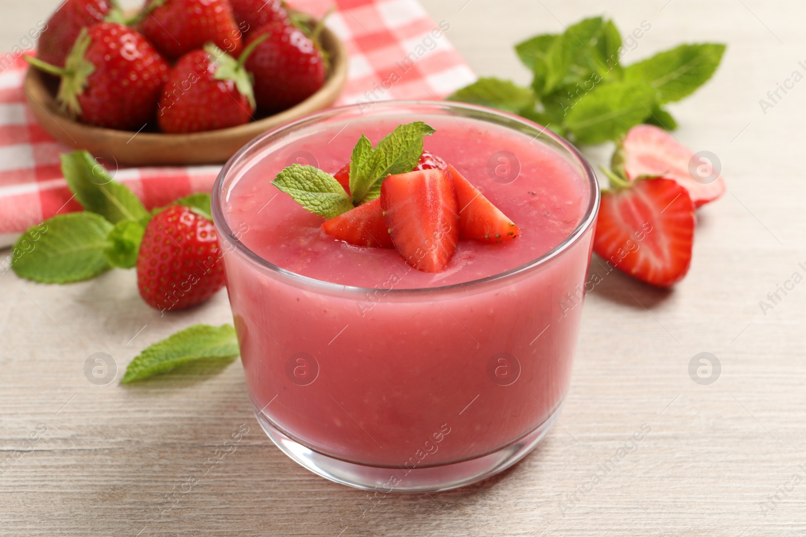 Photo of Delicious strawberry mousse with mint on white wooden table