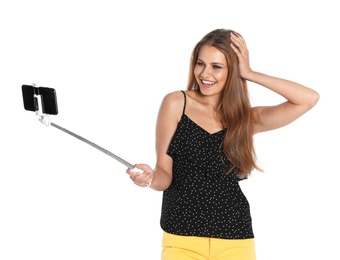 Happy young woman taking selfie on white background