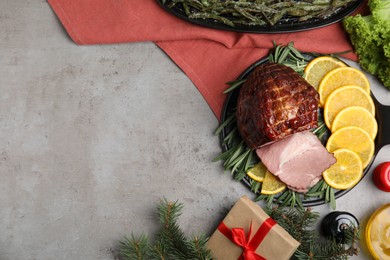 Photo of Festive flat lay composition with delicious ham on grey table, space for text. Christmas dinner