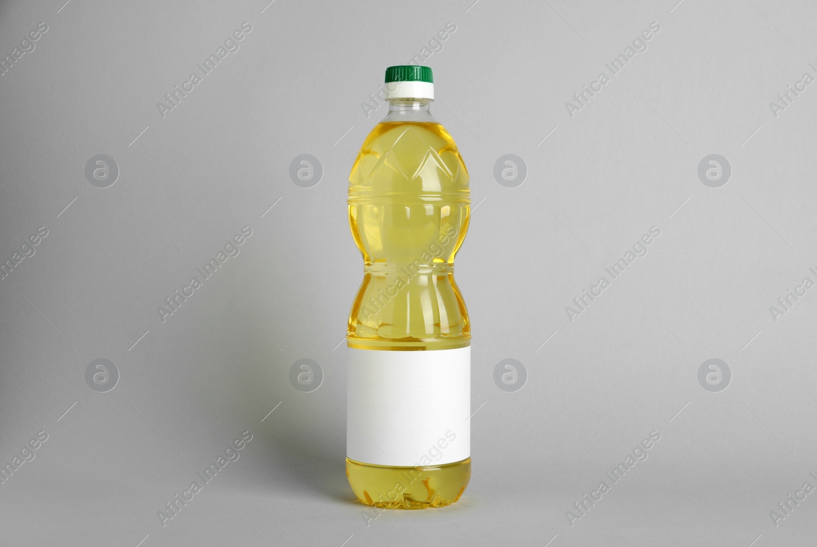 Photo of Bottle of cooking oil on light grey background