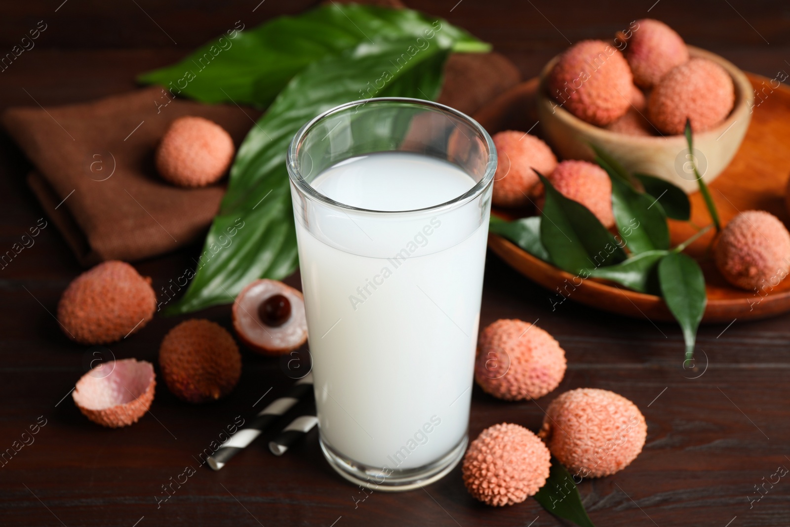 Photo of Lychee juice and fresh fruits on wooden table