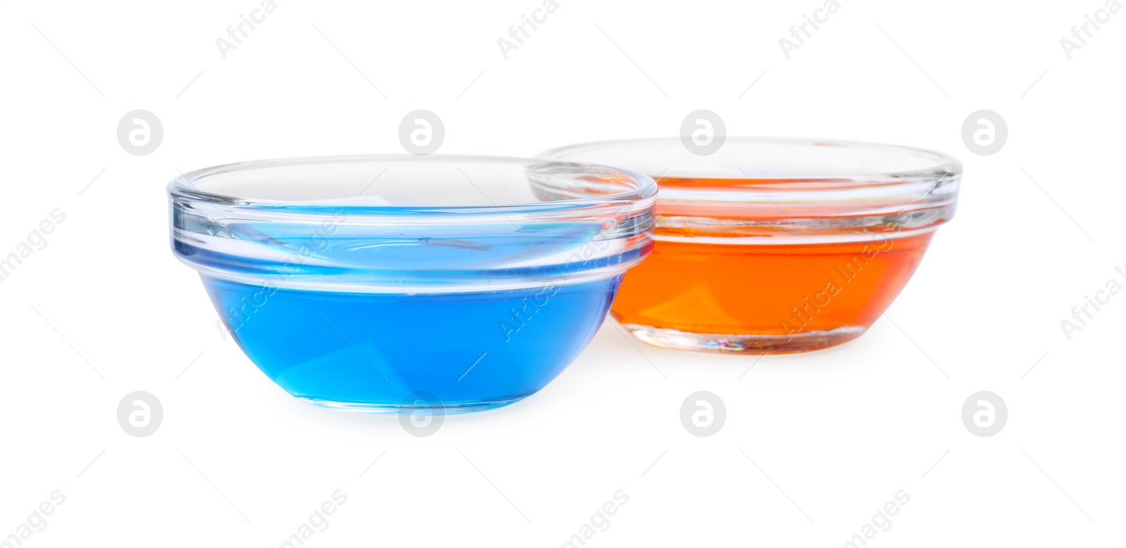 Photo of Glass bowls with different food coloring on white background