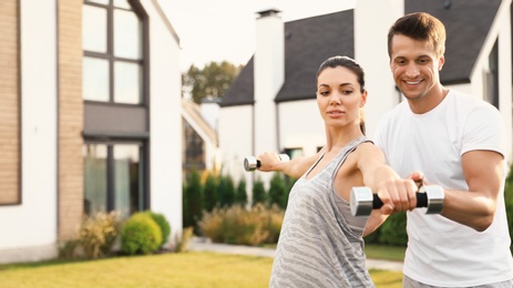 Photo of Sporty couple doing exercise on backyard. Healthy lifestyle