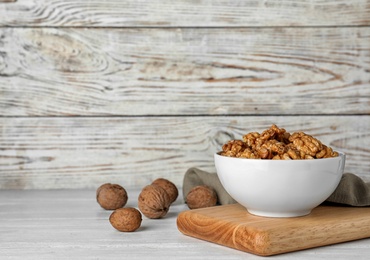 Composition with tasty walnuts on wooden table. Space for text